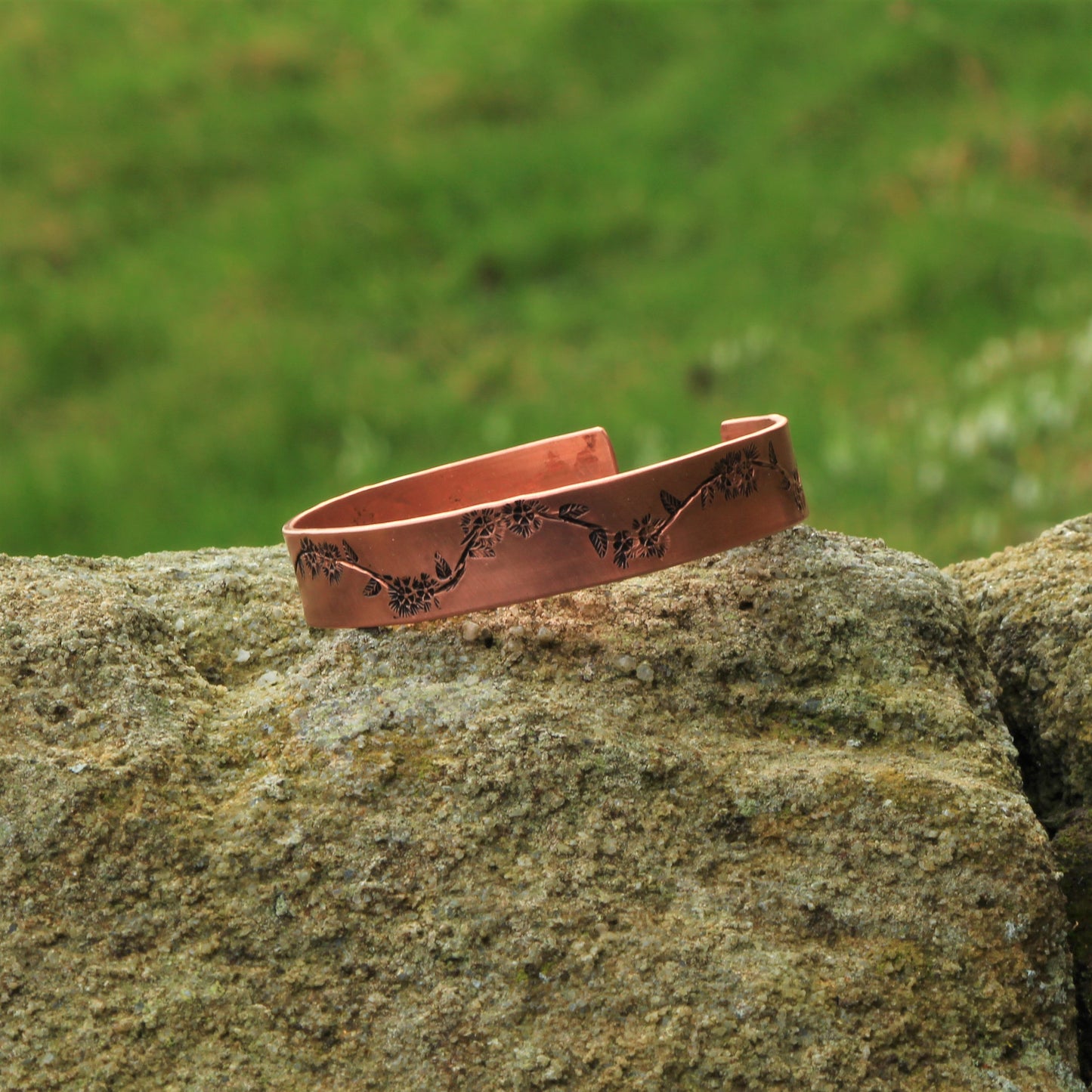 wide copper bangle with pretty floral embossed garland design running the length of the bangle. Adjustable ad available in sizes from 6 inches to 9.5 inches